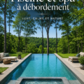 Vue d'une piscine et spa à débordement dans un jardin luxuriant